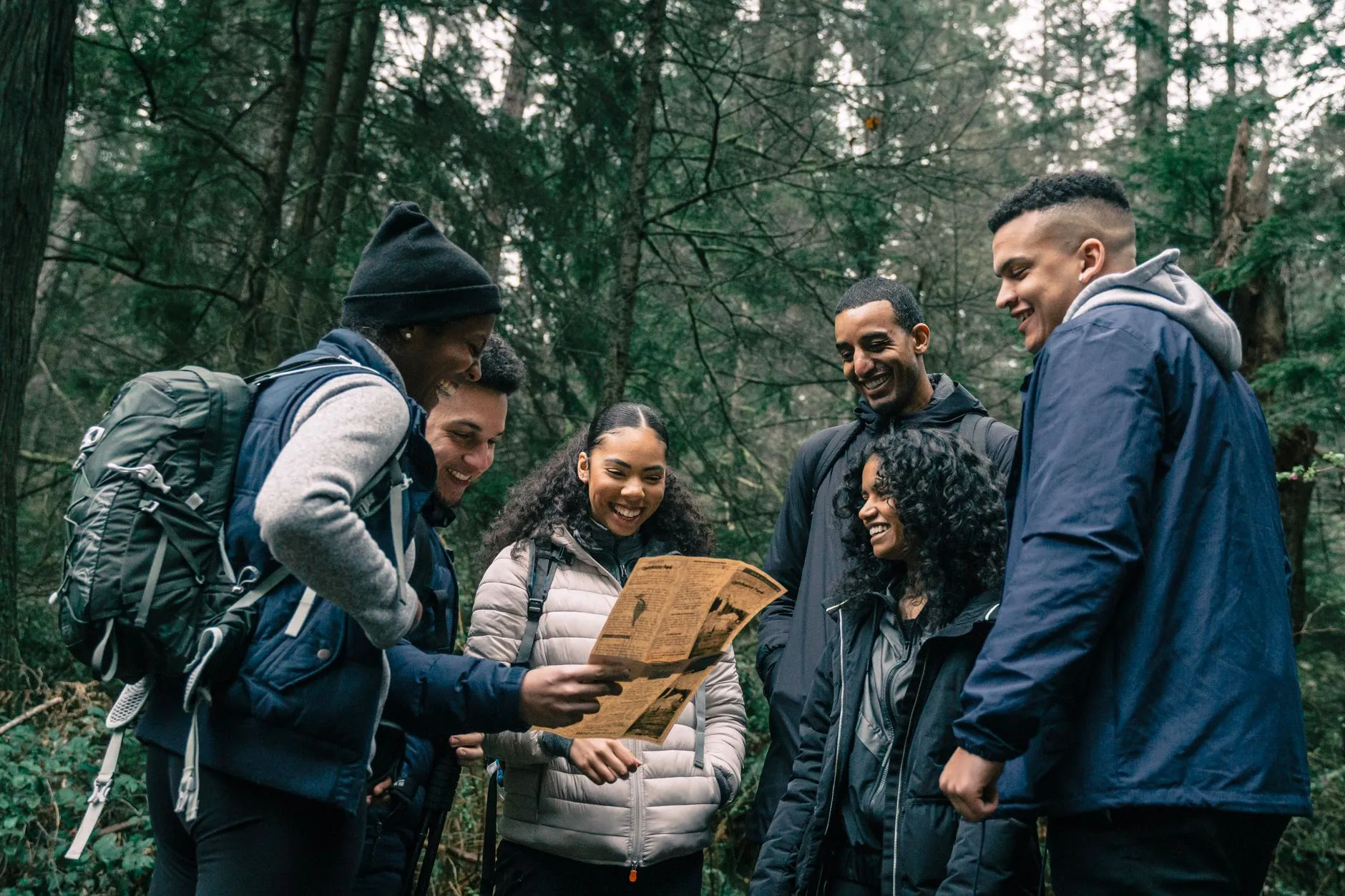 Wandergruppe mit Karte auf einem Waldweg