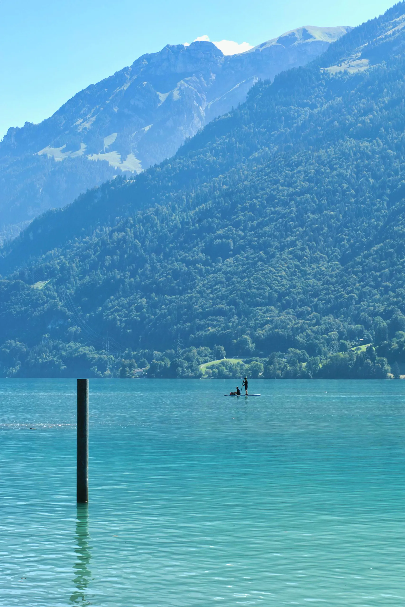 Zwei Menschen auf einem Stand-up-Paddle-Board auf einem türkisen Bergsee